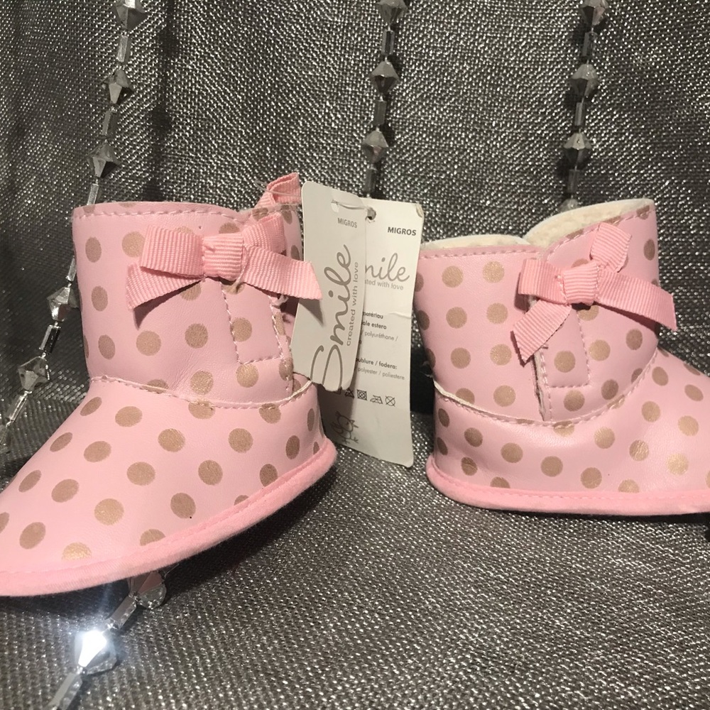 New born 3-9 months pink booties with polka dots in a light golden color.